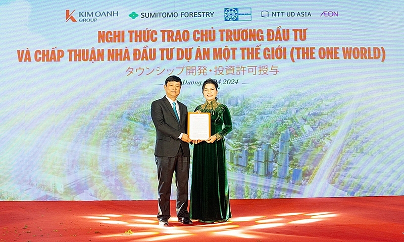 Ông Võ Văn Minh - Chủ tịch UBND tỉnh Bình Dương trao chấp thuận đầu tư cho bà Đặng Thị Kim Oanh đại diện chủ đầu tư dự án Khu đô thị Một Thế Giới – The One World.